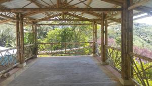 a large wooden covered walkway with a view of trees at country estate in Pasto