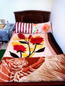 a bed with a bedspread with flowers on it at The stunning of Ismailia's House in Ismailia