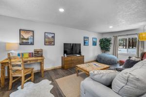 a living room with a couch and a table and a desk at Hot Tub, Fire Pit, Dog Friendly, Heart of Sisters, Amenities in Sisters