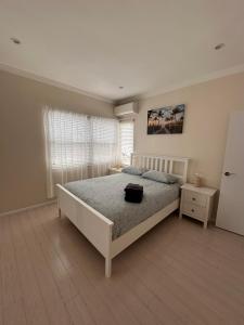 a bedroom with a large bed and a window at Sunny Apt on The Esplanade - Aircon in Cronulla