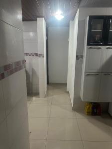 a bathroom with white tiled walls and a tile floor at COP 30 - casa região metropolitana in Ananindeua +8 photos