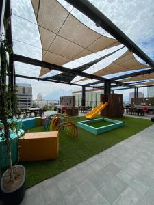 a playground with awning and slides on a roof at Lux 2 BR apartment, swimming pool, gym and free parking spot in downtown Monterrey in Monterrey