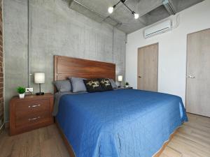 a bedroom with a blue bed with a wooden headboard at Lux 2 BR apartment, swimming pool, gym and free parking spot in downtown Monterrey in Monterrey +53 photos