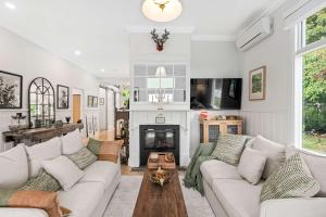 un salon avec un canapé et une cheminée dans l'établissement SPRIGG COTTAGE Adelaide Hills Luxury Retreat, à Crafers