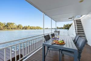 a table on the deck of a boat on the water at Renmark River Villas and Boats & Bedzzz in Renmark