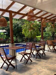 a patio with tables and chairs under a pergola at Hotel el Ancla Campestre in Villeta