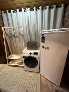 a washing machine and a refrigerator in a room at Charmoso Chalé Hortênsia em Gramado in Gramado +12 photos