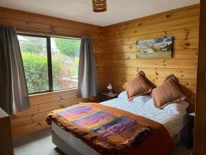 a bedroom with a bed in a wooden room at 4 Alpine Ave in Hanmer Springs