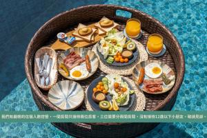 un cesto pieno di prodotti per la colazione e succo d'arancia di M42 RESORT KENTING a Città Vecchia di Hengchun