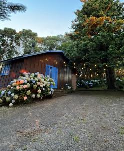 a building with a bunch of flowers in front of it at Charmoso Chalé Hortênsia em Gramado in Gramado