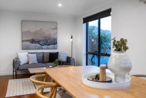 a living room with a table and a couch at Mt Wellington Balcony House - Wake Up to the Summit in Sandy Bay