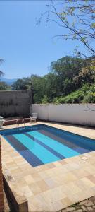a swimming pool on the side of a house at Recanto dos Passaros centro Penedo RJ in Penedo