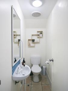a white bathroom with a toilet and a sink at Oceanhaus - Margaret River in Margaret River Town