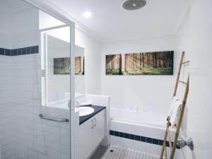 a white bathroom with a sink and a bath tub at Oceanhaus - Margaret River in Margaret River Town +15 photos