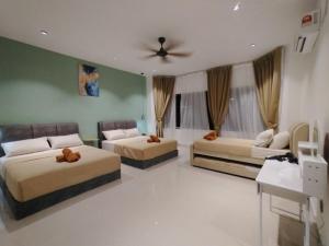 a bedroom with three beds and a ceiling fan at D Laman Santai 17Pax 5R4B Near TC Beach in Kuantan +24 photos