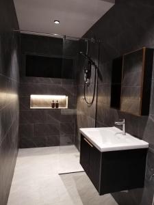 a black bathroom with a sink and a shower at D Laman Santai 17Pax 5R4B Near TC Beach in Kuantan