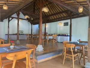 a dining room with wooden tables and chairs at Gianyar Hotel in Gianyar