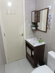 a bathroom with a sink and a mirror and a toilet at Apto Paris in Santa Maria +45 photos
