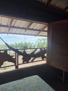 a hammock in a room with a view of the ocean at La Bamba in Termales - agua caliente - nuqui