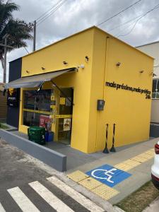 a yellow building with a handicapped parking sign on it at Ilha Aruba Condomínio na Cohama próx a praia in São Luís