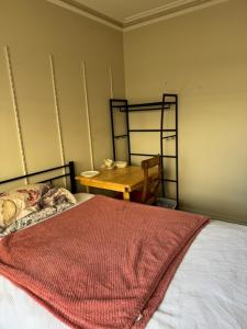 a bedroom with a bed and a wooden table at Single room with shared bathroom 2 in Glen Waverley