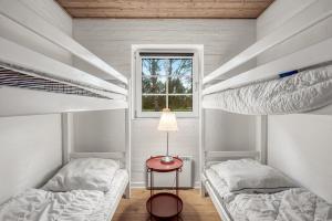 Habitación con 2 literas y mesa con lámpara. en Renovated Thatched Pool House By The North Sea For 16 People, en Ulfborg 32 fotos más