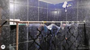 a black tiled bathroom with a towel rack and a shower at Casa Completa 2 Santa Alexandrina in Rio de Janeiro