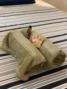 a green towel with a bottle on a bed at Loft luxo à beira-mar com hidromassagem in Angra dos Reis