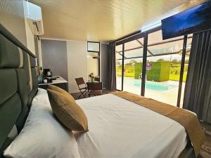 a bedroom with a bed and a desk and a view of a pool at Casa Cristal # 1 in Fortuna