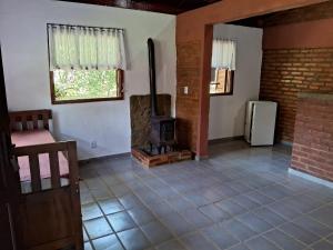 a living room with a fireplace and a stove at Sitio Serenar Chalés Equipados in Penedo