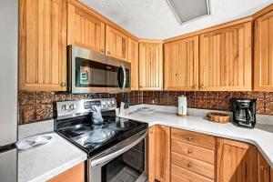 a kitchen with wooden cabinets and a stove top oven at Above The Clouds in Gatlinburg
