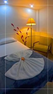 Un dormitorio con una cama con una flor. en Hotel Marinilla Oriente, en Marinilla