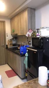 a kitchen with a sink and a stove and a refrigerator at LJ's escape 2BR COAST Residences in Manila
