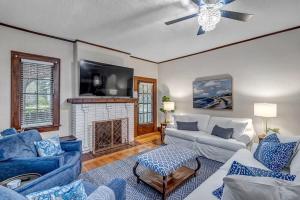 a living room with blue furniture and a fireplace at Elegant Mansion on Park in Historic Avondale in Jacksonville