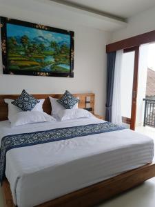 a bedroom with a large bed with a painting on the wall at Tulak House in Blahbatu