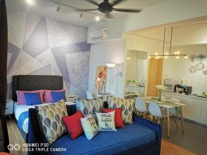 a living room with a blue couch with colorful pillows at HomeZz Imperium Residence Kuantan Studio Seaview in Kuantan +48 photos
