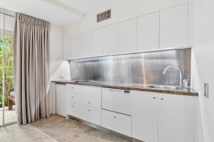 a kitchen with white cabinets and a sink at Noosa Blue Resort in Noosa Heads +162 photos