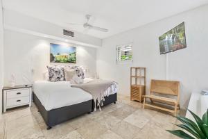 a bedroom with a bed and a chair at Noosa Blue Resort in Noosa Heads
