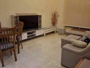 a living room with a flat screen tv and a couch at Compound Montaza hadayaq October in ‘Ezbet `Abd el-Ḥamîd