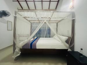a bed with a canopy in a room at Calm Palace in Weligama