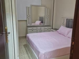 a bedroom with a bed and a large mirror at Compound Montaza hadayaq October in ‘Ezbet `Abd el-Ḥamîd