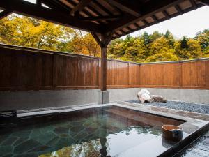 a swimming pool in a backyard with a wooden fence at Hotel Kikori in Hida