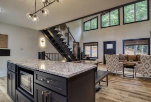 a kitchen and living room with a staircase and a table at Arise in the Glades in Gatlinburg