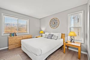 a bedroom with a white bed and two windows at Heavenly Haven in Gatlinburg