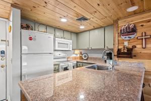 a kitchen with a white refrigerator and a sink at Whispering Woods Condo in Gatlinburg
