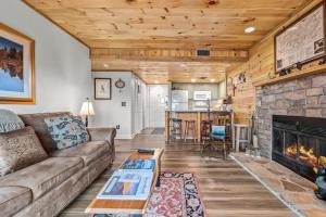 a living room with a couch and a fireplace at Whispering Woods Condo in Gatlinburg