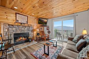 a living room with a couch and a fireplace at Whispering Woods Condo in Gatlinburg +16 photos