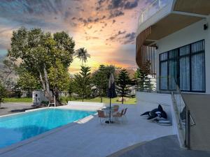 a house with a swimming pool with a table and chairs at Celine House by Craft Village in Chaweng