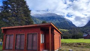 een kleine hut in een veld met een berg bij Cabañas Puerto Aysen in Puerto Aisén +3 foto's
