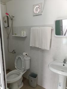 a white bathroom with a toilet and a sink at Mumzai House in Ko Mook +21 photos